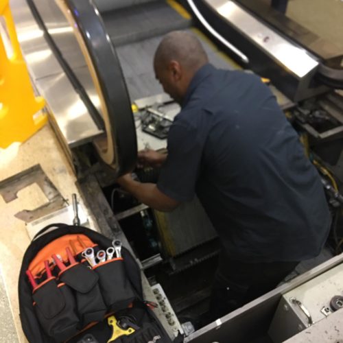 AMS employee carrying out escalator repairs