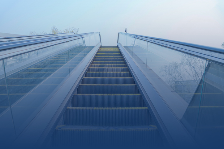 view of top of outdoor escalator from the bottom